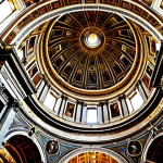 **Image of St. Peter's Basilica**: A breathtaking view of St. Peter's Basilica, showcasing its grand architecture and the famous dome designed by Michelangelo. The scene should capture the majesty of the basilica with visitors admiring its beauty, highlighting the historical significance of this spiritual landmark.